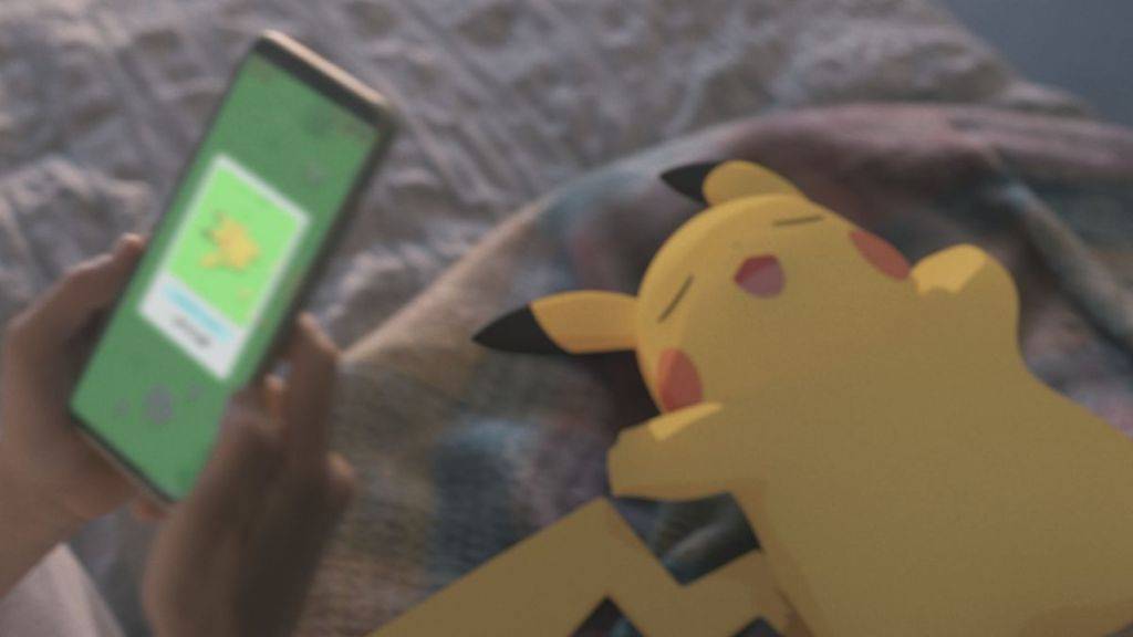 A sleepy Pikachu with a person using the Pokemon Sleep app